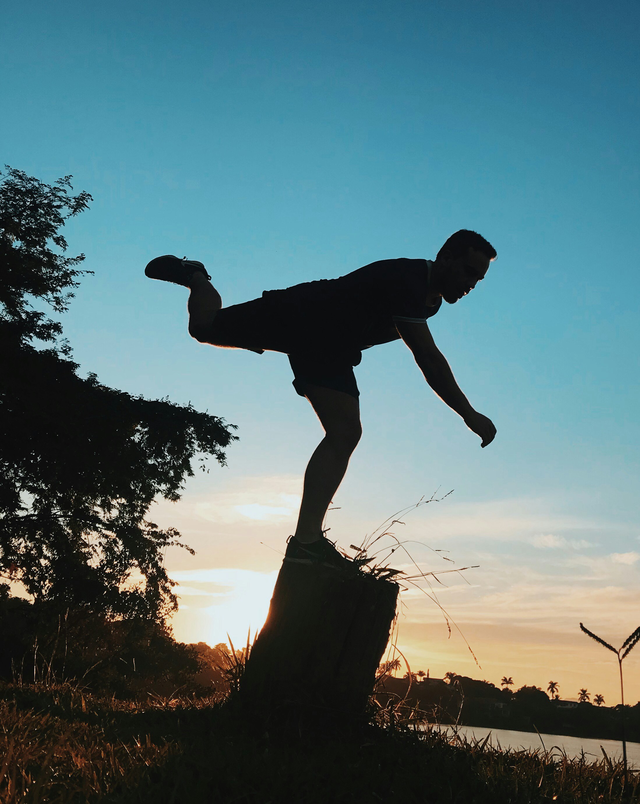 silhouette of man standing with one foot